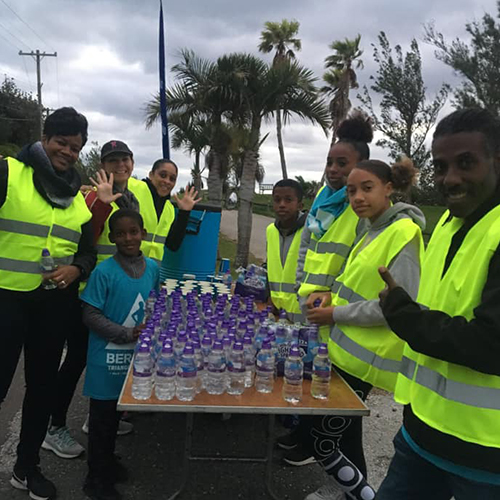 Volunteers of all ages staff a water stop during the Bermuda Triangle Challenge